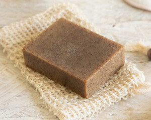 Brown handmade soap bar on soap saver bag  close up. Organic skincare products