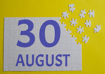 30 august calendar date on a white puzzle with separate details. Puzzle on a yellow background with a blue inscription