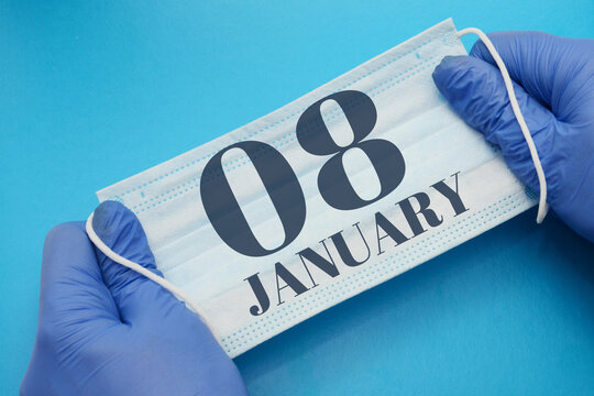 8 january day of month. Doctor holding an antivirus mask in blue medical gloves on blue background. Protection from disease