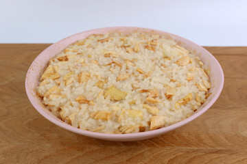 Rice porridge with apples in a bowl close-up.
