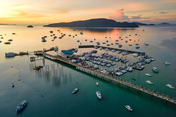 Aerial drone view of Chalong Pier during sunrise in Phuket, Thailand. Many yachts, catamaran and...