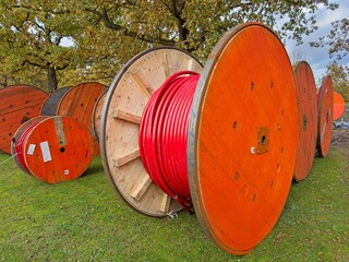 Large round, wooden, orange cable reels.
