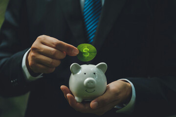 Saving, and Investment concept. Businessmen hold green leaves with dollar symbols saved in the piggy bank. Recycle and Renewable Energy. Saving and Investment in a green business environment.ESG