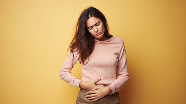 sad young woman holding her stomach, illness, cramps, health, color background, girl suffering, painful periods, stomach-ache, abdominal, griping, bellyache, tummy-ache, gripes, portrait, ill, pastel