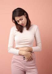 Obraz premium sad young woman holding her stomach, illness, cramps, health, color background, girl suffering, painful periods, stomach-ache, abdominal, griping, bellyache, tummy-ache, gripes, portrait, ill, pastel