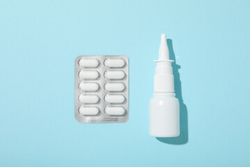 Nasal spray with pills on a blue background
