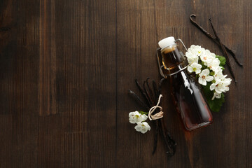 Obraz na płótnie Canvas Vanilla extract in a bottle on a wooden background