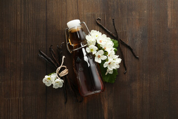 Vanilla extract in a bottle on a wooden background