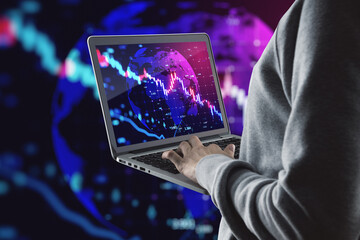 Close up of hacker hands using laptop falling forex chart on blurry grid background. Crisis, hacking, recession and financial loss concept.