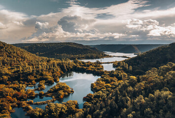 Sun-kissed aerial view of KRKA waterfalls, capturing the dramatic Croatian landscape and intertwining waterways.