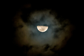 This is a photo of a pale yellow half moon in the night sky.