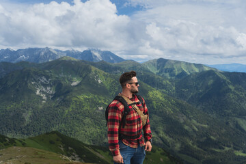 A man in a shirt is a traveler on the top of the Polish Tatra Mountains.