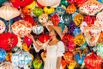 Asian traveler woman is enjoy looking lanterns in old town Hoi An, Woman choosing a lamp at Hoi An...