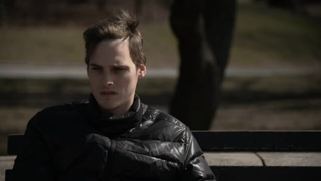 thoughtful boy sitting on a bench in new york