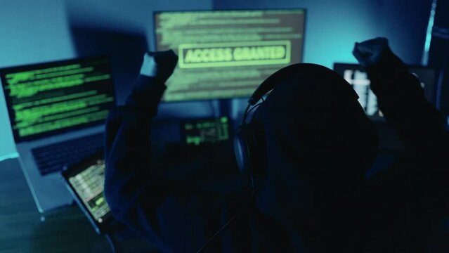 Happy professional hacker raised hand celebration successful after login breaks into data servers and infects their systems with a virus. Security password login, Cyber crime, Digital system security