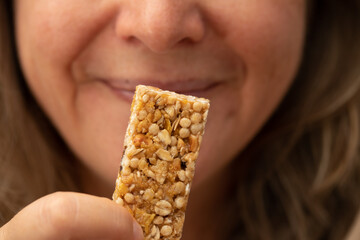 Detail shot of middle age woman eating cereal cookie - Powered by Adobe