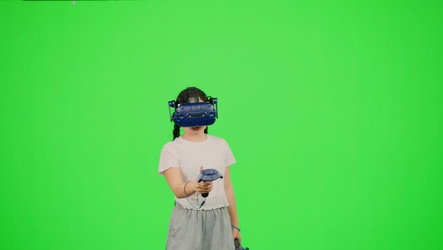 Child in virtual reality paint imagination picture on chroma key green screen. The little girl design artist VR headset drawing picture in virtual reality creativity game. Concept VR art design game