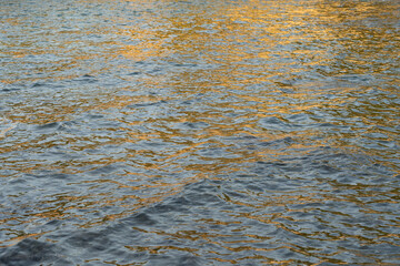 abstract sea water and golden reflections on the water surface in the morning natural sea water background