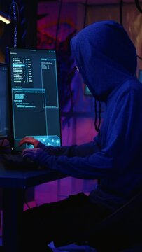 Vertical video Hackers in dark abandoned warehouse using phishing technique that tricks users into revealing sensitive information. Rogue developers stealing passwords from low security systems, dolly