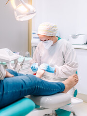 Female podiatrist doing chiropody in her podiatry clinic. Selective focus