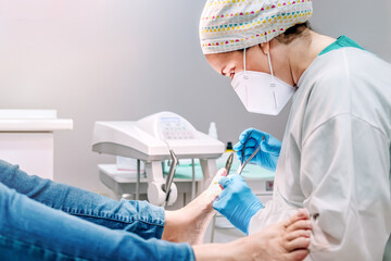 Female podiatrist doing chiropody in her podiatry clinic. Selective focus