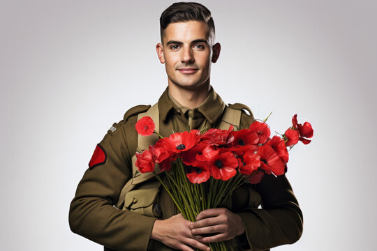 Portrait of a military soldier holding a bunch of red poppy flowers, the symbol of remembrance