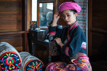 Pretty Asian Tai Lue women in beautiful traditional costumes doing beauty makeup relax in the ancient house—concept cute girl wearing to preserve classic cultural dress original style.