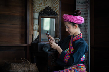 Pretty Asian Tai Lue women in beautiful traditional costumes doing beauty makeup relax in the...