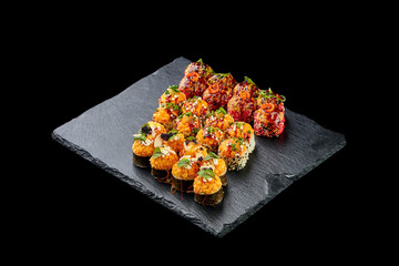 Set of baked sushi roll in tempura with salmon on a black background. Japanese food, photo for menu