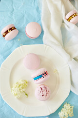 Assorted sweet french pink macarons on blue background