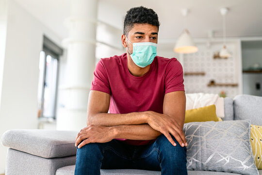 Quarantine self-isolation. Sad young african american man in a medical mask at home