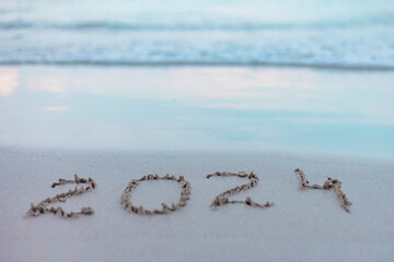 handwritten inscription 2024 on the sand by the sea