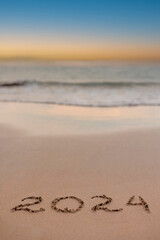 handwritten inscription 2024 on the sand by the sea