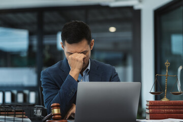 Legal counsel is sitting at table, covering his face. client crisis negotiating concept.