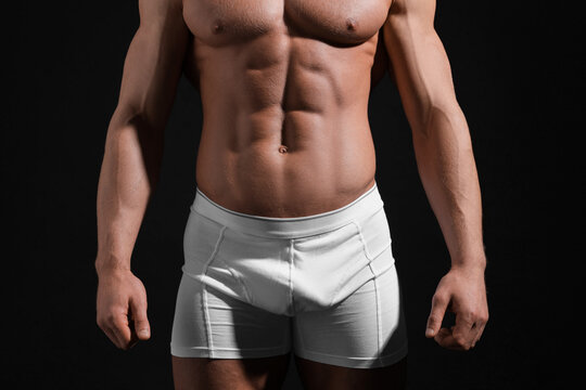 Young man in stylish white underwear on black background, closeup