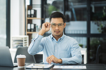 Obraz premium Businessman using laptop computer in office. Happy man, entrepreneur, small business owner working online.