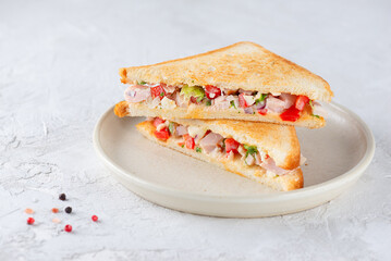 Chopped Italian sandwich with ham, cheese, vegetables and spices in a plate.