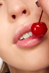 Close up photo of cherry in woman mouth. Summer sexy fruits. Beautiful woman with cherry.