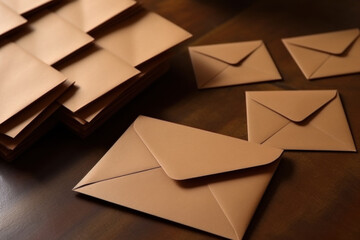 brown paper envelopes on a dark wooden tabletop - obrazy, fototapety, plakaty
