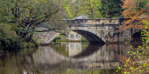 Calver bridge over the river Derwent, with the old Shuttle House beyond, Peak District, Derbyshire.