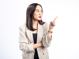 A portrait of an Indonesian Asian woman wearing a cream-colored blazer, posing as if having an idea with her index finger pointing upward. Isolated against a white background.