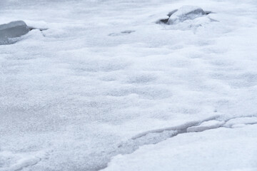 Melted snow and ice on the ground. Thaw, cloudy winter day.