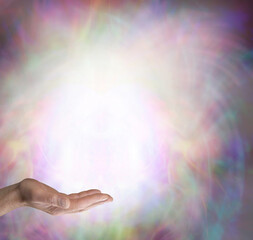 Sending you high frequency love and light vibes - open male hand with white light against beautiful...