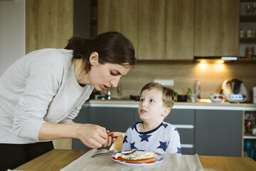 Mother with son having breakfast in the kitchen