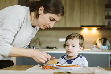 Mother with son having breakfast in the kitchen
