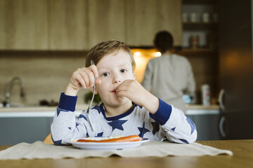 Portrait of a little boy having breakfast in the kitchen at home