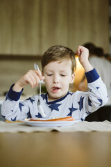 Portrait of a little boy having breakfast in the kitchen at home