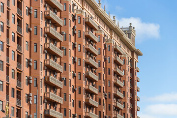 Fototapeta premium Facade of a beautiful residential complex in Kazakhstan. Balustrade on the roof of a multi-storey building. Balconies with balusters on the house.