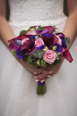 Wedding bouquet in bride's hand. Bride stands in a white wedding dress with a bouquet of flowers. stylish bridal bouquet. 