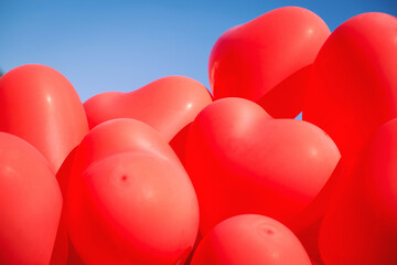 Holiday party decoration. Red heart balloons. Bunch of balloons outdoors.